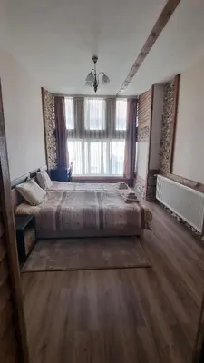 a large bedroom with two beds and a large window at Pirin Studios in Bansko