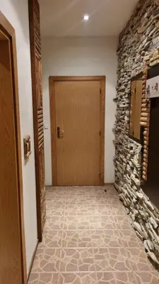 a hallway with a wooden door and a stone wall at Pirin Studios in Bansko