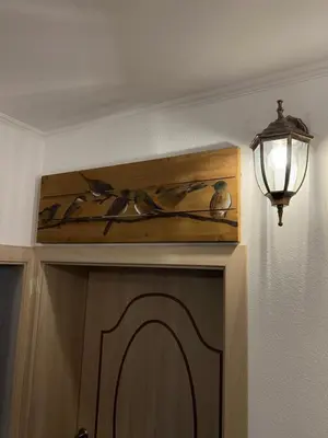 a light on a wall next to a cabinet with a bird painting at Guest House Tanevi in Devin