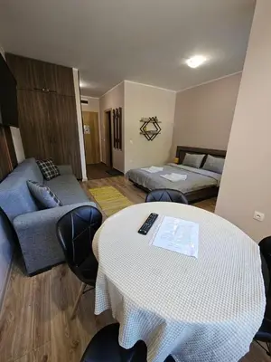 a living room with a bed and a table and chairs at BoroHome in Borovets