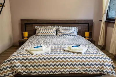 a bedroom with a large bed with two pillows on it at BoroHome in Borovets