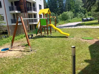 a playground with a slide in the grass at BoroHome in Borovets