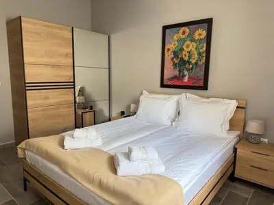 a bedroom with a large bed with towels on it at Вила Рафаела-Мартина in Dobrinishte