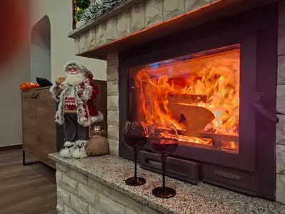 a fireplace with a santa clause and two glasses of wine at Вила Рафаела-Мартина in Dobrinishte