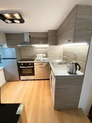 a kitchen with stainless steel appliances and wooden floors at Stylish apartment, very good location! in Sofia
