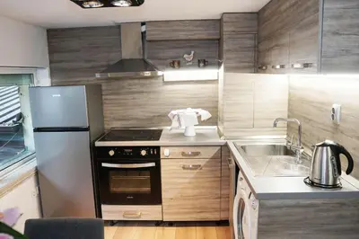 a small kitchen with a stove and a refrigerator at Stylish apartment, very good location! in Sofia