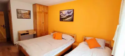 two beds in a room with yellow walls at Villa Tangra in Grashtitsa