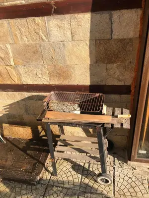 a cage sitting on a picnic table in front of a brick wall at One Bedroom Flat With Garden and Barbeque in Bansko