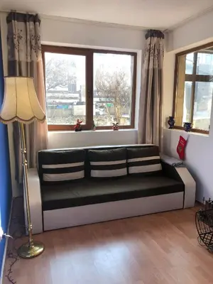 a living room with a couch and a window at One Bedroom Flat With Garden and Barbeque in Bansko