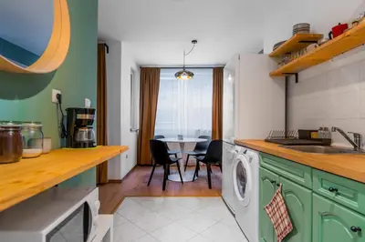 a kitchen with green cabinets and a table with chairs at Modern&Stylish Studio in City Centre by Flat Mаnager in Sofia