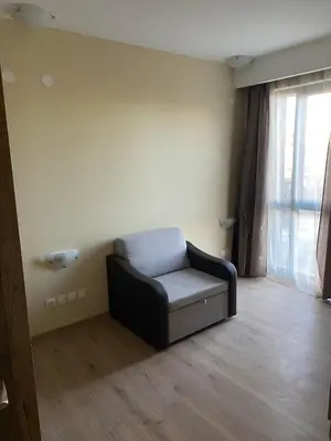 a living room with a couch and a window at Grand Apartments in Bansko