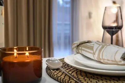 a candle on a table with a plate and a glass at Ski&Stay Studio Bansko in Bansko