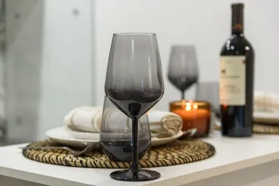 a wine glass sitting on a table with a bottle of wine at Ski&Stay Studio Bansko in Bansko