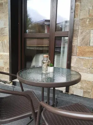 a glass table and two chairs on a patio at Ski&Stay Studio Bansko in Bansko