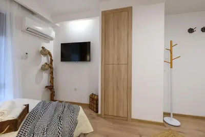 a bedroom with a bed and a tv on a wall at Ski&Stay Studio Bansko in Bansko