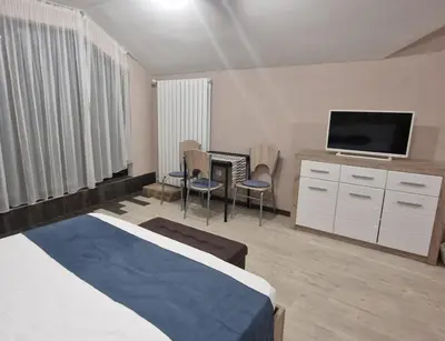 a hotel room with a bed and a flat screen tv at B55 Studio in Borovets