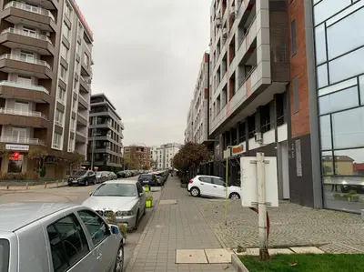 a city street with parked cars and buildings at SliverCity next to paradise mall in Sofia