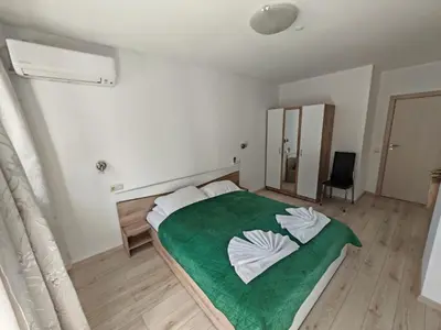 a bedroom with a large bed with a green blanket at Gondola Ski Lift Apartment in Bansko