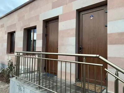 a building with a wooden door and a balcony at Elegant and cozy room ARAKS in Kostinbrod