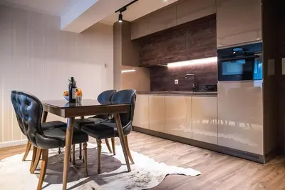 a kitchen with a wooden table and black chairs at Lux Apart Karlovo in Karlovo