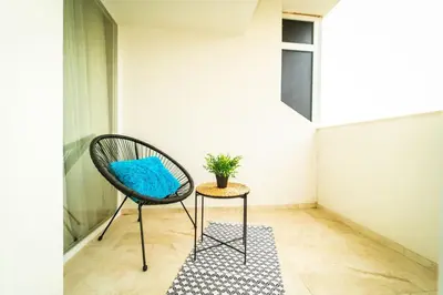 a chair with a blue pillow next to a table at Lux Apart Karlovo in Karlovo