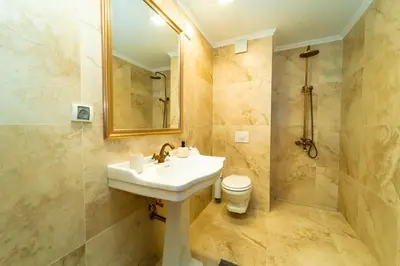 a bathroom with a sink and a toilet and a mirror at Lux Apart Karlovo in Karlovo