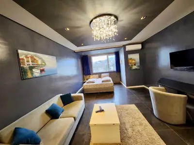 a large living room with a couch and a bed at Joy Station Cozy Studio in Sofia
