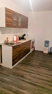 a kitchen with a sink and a wooden floor at Елегантен градски апартамент с обширна тераса in Pernik
