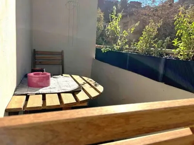 a wooden table with a pink bucket on a balcony at Cozy & Boho Top Center Apartment in Sofia