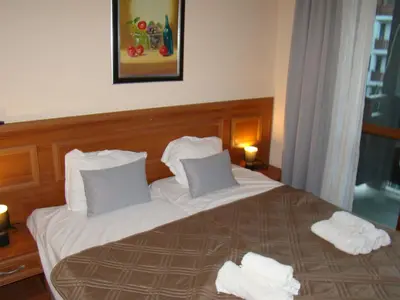 a bed in a hotel room with towels on it at Dino privates apartments Emerald in Bansko