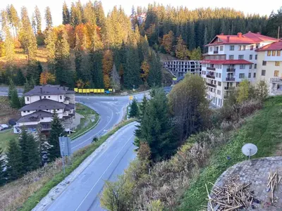 an empty road in a city with buildings and trees at Апартамент за гости Свети Трифон in Pamporovo