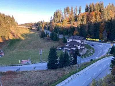 a house on a hill next to a road at Апартамент за гости Свети Трифон in Pamporovo