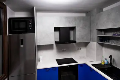 a kitchen with blue cabinets and a stainless steel refrigerator at Very Spacious & Modern 3Bed near Airport & Centre in Sofia