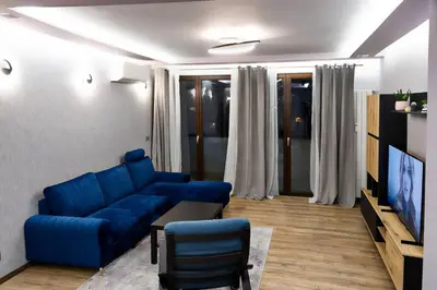 a living room with a blue couch and a tv at Very Spacious & Modern 3Bed near Airport & Centre in Sofia