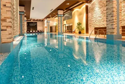 a swimming pool in a hotel with blue water at Apartaments by Zenit in Terra Complex B16 and D09 near Bansko in Razlog
