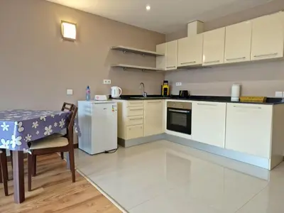 a kitchen with white cabinets and a table and a table and a table at Apartaments by Zenit in Terra Complex B16 and D09 near Bansko in Razlog