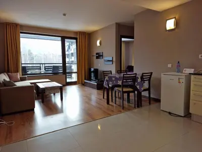a living room with a kitchen and a table and chairs at Apartaments by Zenit in Terra Complex B16 and D09 near Bansko in Razlog