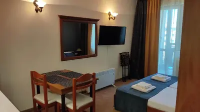 a small room with a table and a bed and a mirror at Annett apartments at Emerald hotel in Bansko