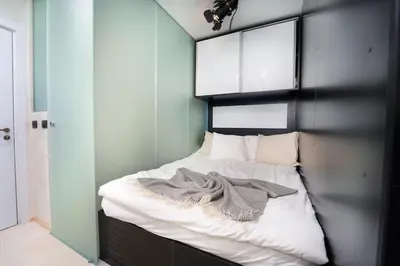 a small bedroom with a bed with a black headboard at Stylish Cozy Studio with fireplace in Bansko
