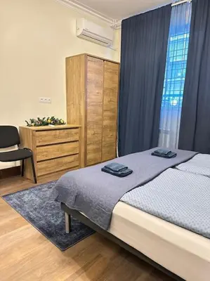 a bedroom with a bed and a cabinet and a chair at City centre stylish apartament with private backyard in Sofia