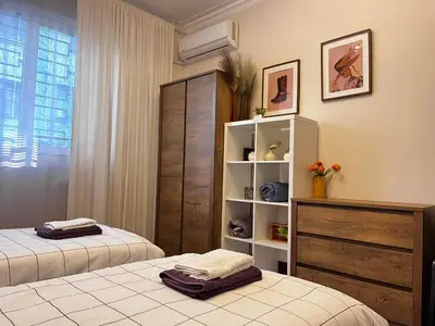 a bedroom with two beds and a book shelf at City centre stylish apartament with private backyard in Sofia
