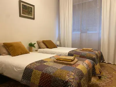 two beds in a bedroom with a quilt on them at City centre stylish apartament with private backyard in Sofia