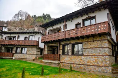 an old brick house with a balcony on top of it at Къщи за гости НЕСИ in Leshten