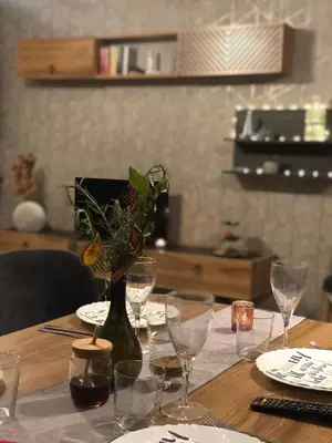 a wooden table with wine glasses and a vase with flowers at Luxury Apartments Studenets in Pamporovo