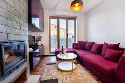 a living room with a red couch and a fireplace at Warm&Cozy Studio with Patio in Bansko