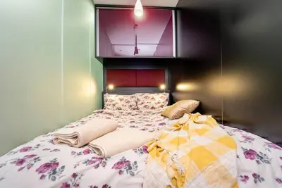 a bedroom with a large bed with a floral blanket at Warm&Cozy Studio with Patio in Bansko