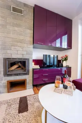 a living room with a fireplace and purple cabinets at Warm&Cozy Studio with Patio in Bansko