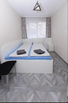a bedroom with a bed with two towels on it at The yellow appartment in Sofia