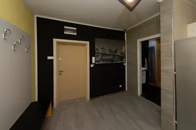 a hallway with a white door and a black wall at The yellow appartment in Sofia