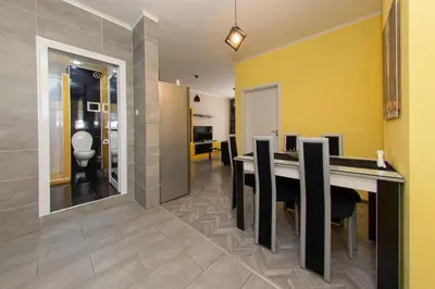 a dining room with a long table and yellow walls at The yellow appartment in Sofia